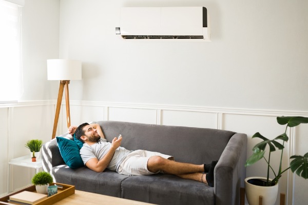 man relaxing under ductless mini-split air conditioner