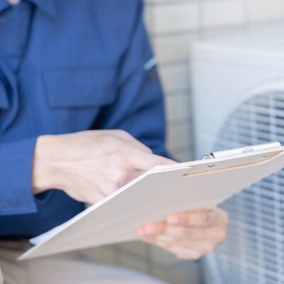 hvac technician inspecting air conditioner