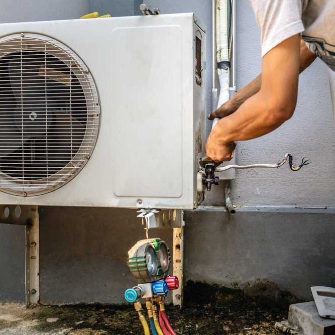 technician tinkering with an HVAC system’s electronic components