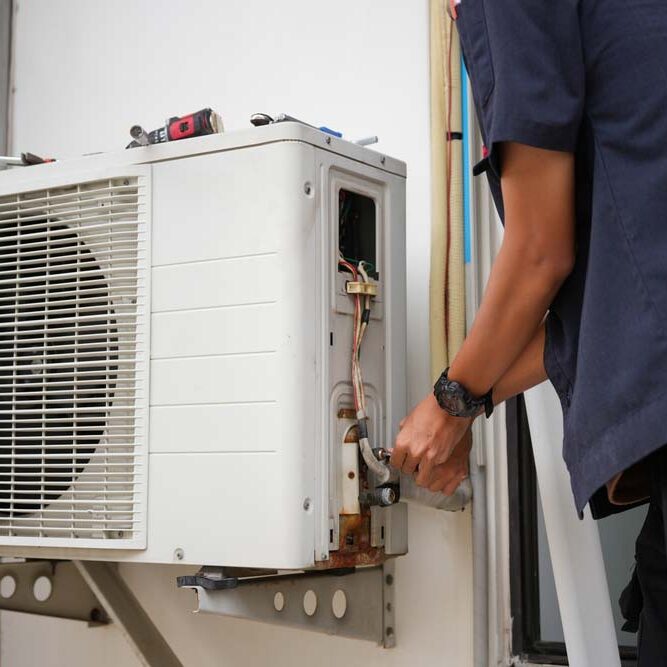 technician tinkering with an HVAC system